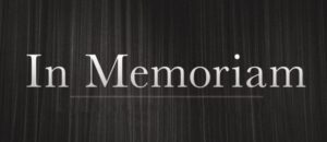 Elegant text that reads 'In Memoriam' against a dark, textured background, conveying a somber and respectful tone.